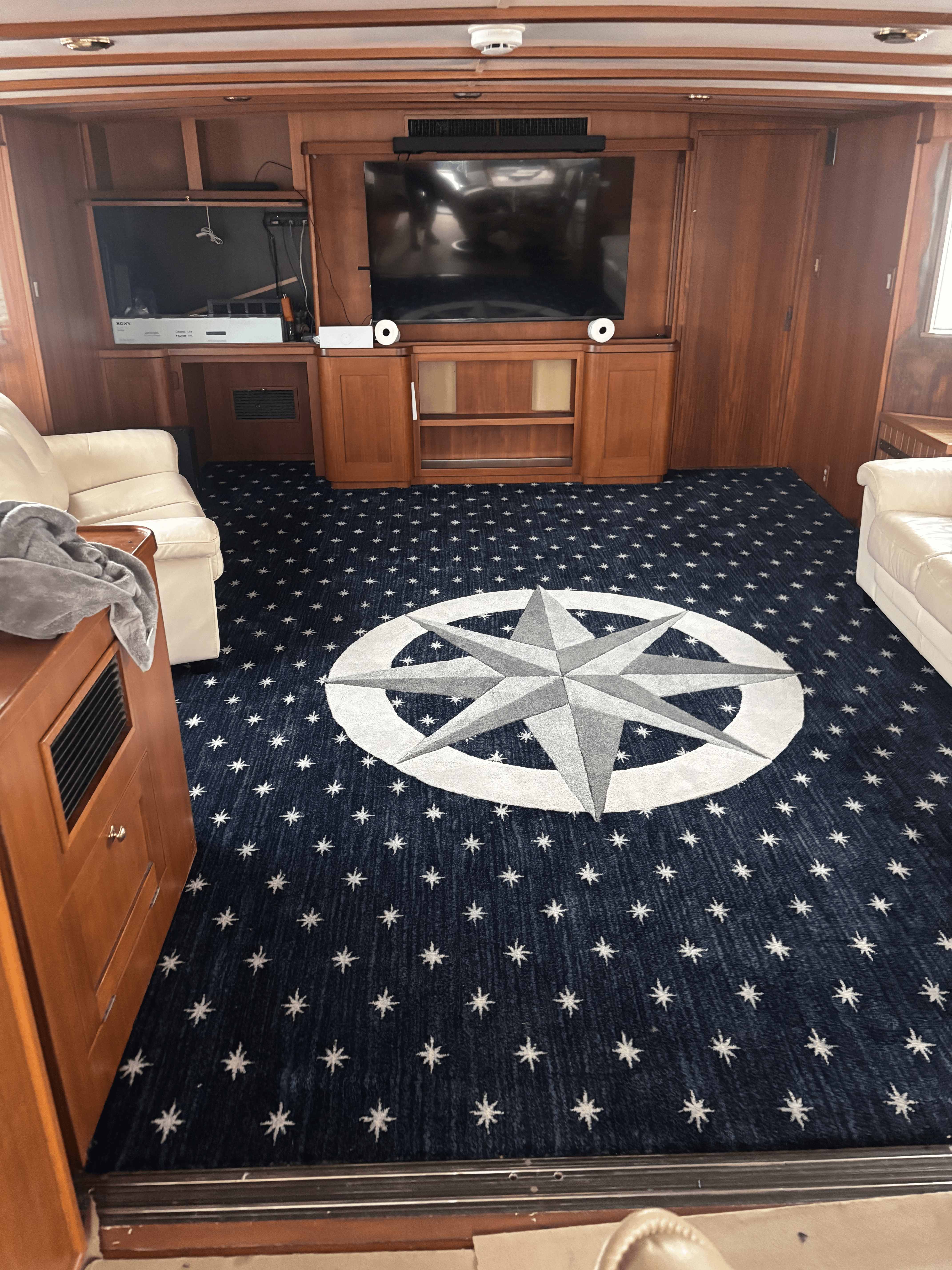 Finished navy compass-rose star medallion carpet in a yacht salon