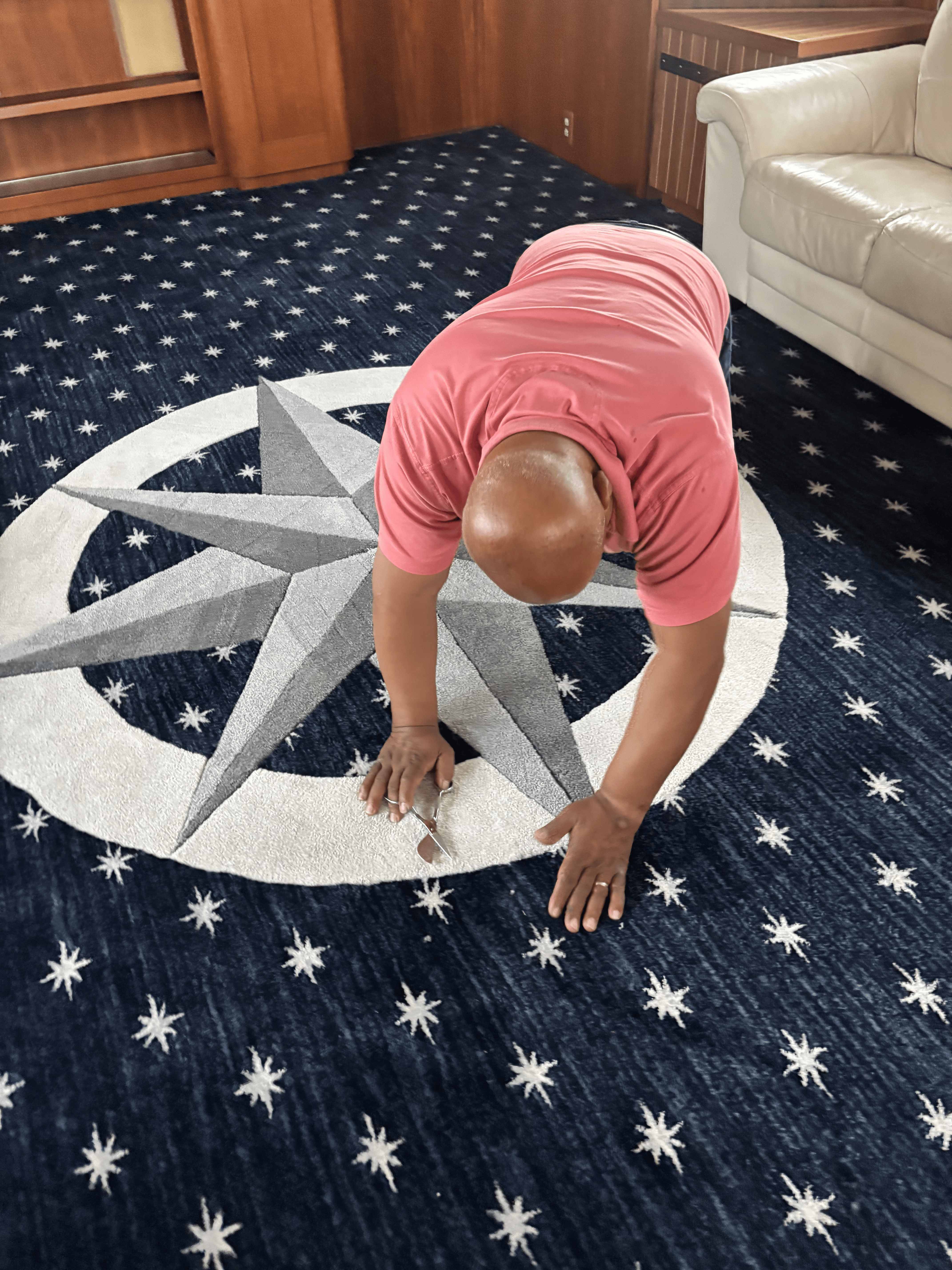 Installer hand-cutting and fitting a custom compass-rose rug