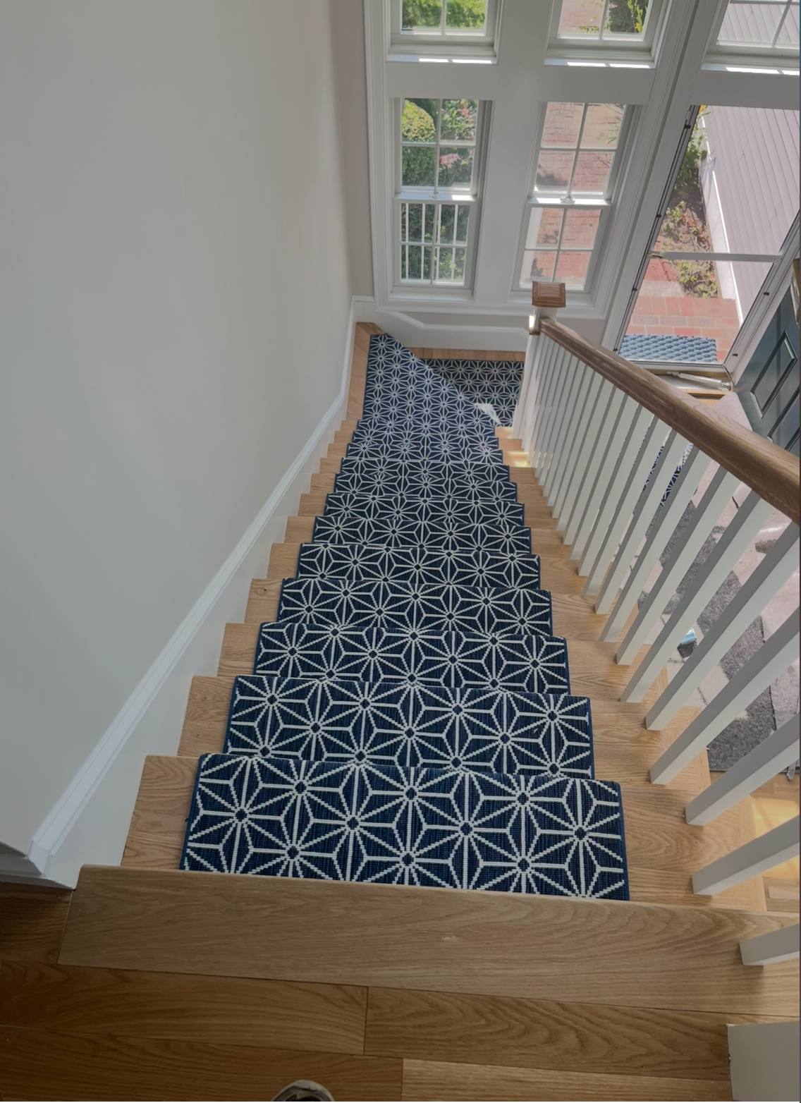 Navy and white geometric star pattern stair runner on oak treads