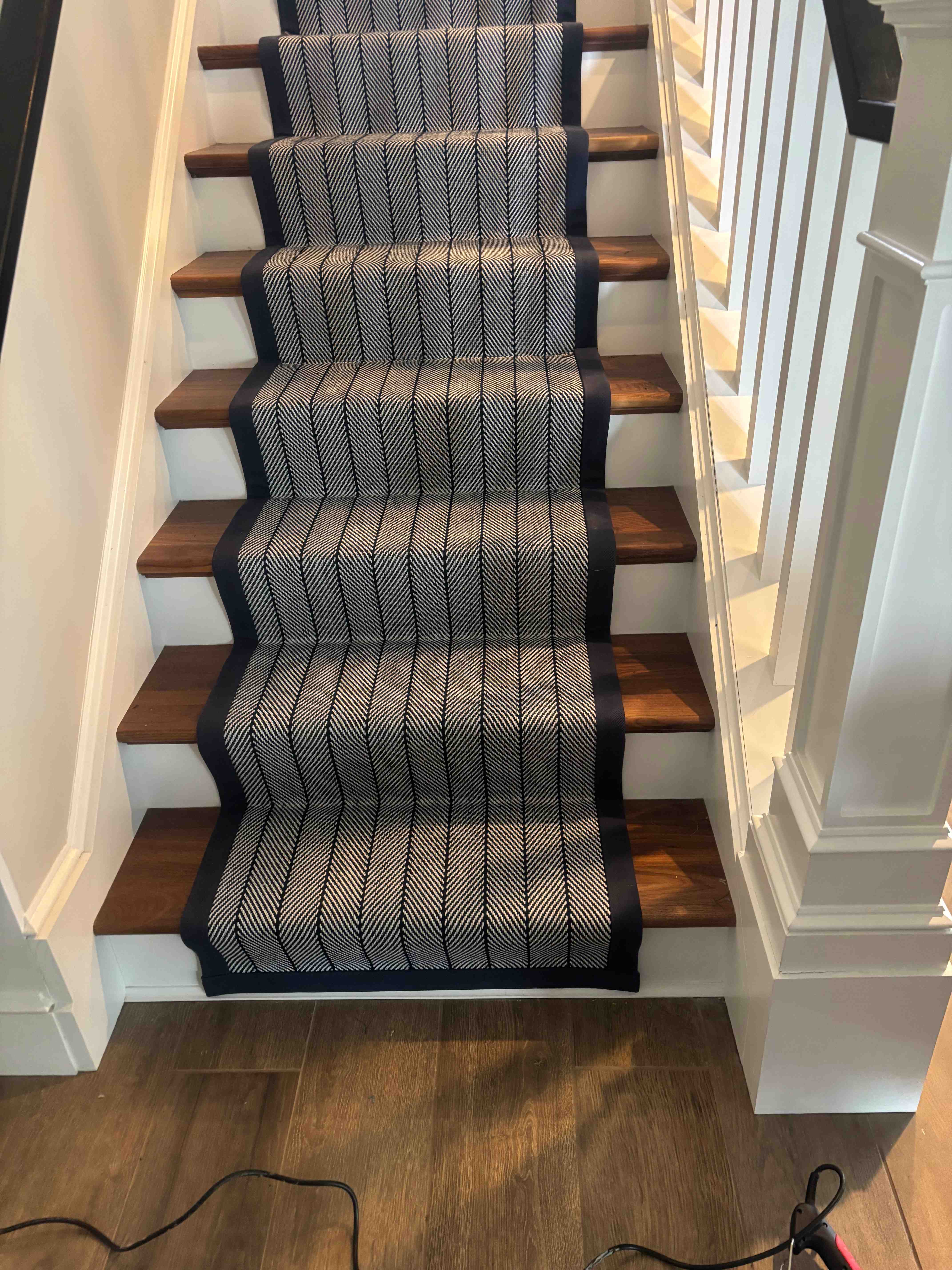 Navy and cream herringbone stair runner on stained hardwood treads